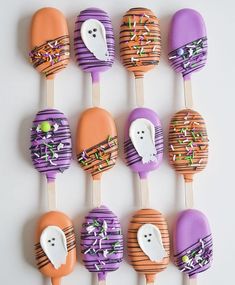 halloween cake pops decorated with sprinkles and ghost faces on wooden skewers