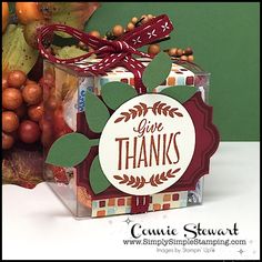 a clear box with a red ribbon tied around it that says give thanks on the front