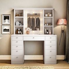 a white desk with drawers and lights on it in front of a wall mounted mirror