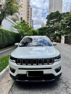 a white jeep parked on the side of a road