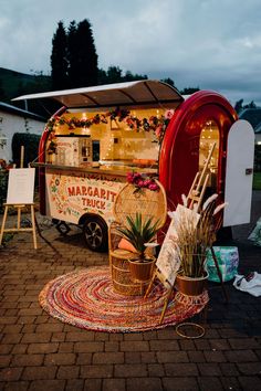 a food truck parked on the side of a road next to a potted plant