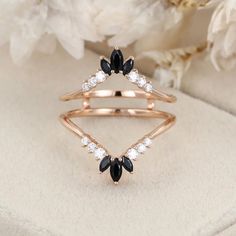 a black and white diamond ring sitting on top of a flower