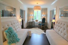 a living room filled with white couches and lamps