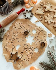 cookie cutters and cookies on a table with christmas decorations