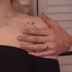 a woman's chest with two rings and stars on her left side, while the other half has a crescent tattoo