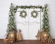 two christmas wreaths are hanging on a white door with greenery and lights around it