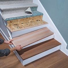 a man that is standing next to some stairs with wood flooring on top of it