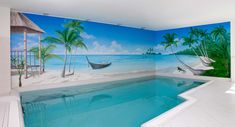 an indoor swimming pool with palm trees and boats painted on the wall next to it