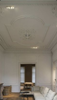 an empty living room with white furniture and chandelier