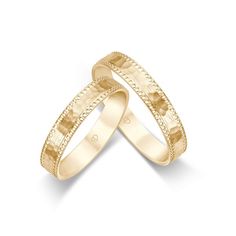 two gold wedding bands with intricate designs on each band, set against a white background