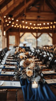 the tables are set up with blue linens and white flowers in centerpieces