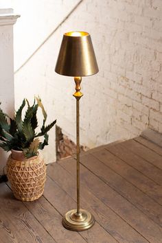 a floor lamp sitting next to a potted plant