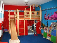 a child's bedroom with a bunk bed, slide and play area in the corner