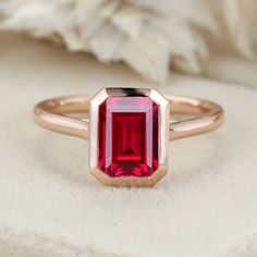 Experience the radiance of red with our Emerald Cut Lab Grown Ruby Engagement Ring in rose gold, a perfect solitaire choice for July birthstone enthusiasts. Luxury Timeless Ruby Ring With Bezel Setting, Red Ruby Solitaire Rings, Modern Ruby Engagement Ring, Ruby Bezel Engagement Ring, Emerald Cut Ruby Promise Ring With Bezel Setting, Emerald Cut Ruby Ring With Bezel Setting, 14k Gold Ruby Ring With Bezel Setting, Emerald Cut, Red Ruby Ring In 14k Rose Gold, Red Ruby Promise Ring With Bezel Setting