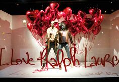 a window display with red heart balloons and the words i love you, happy valentine's day