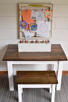 a white table with a wooden bench in front of it