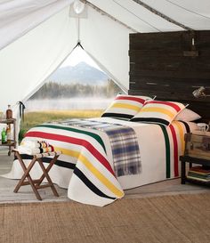 a bedroom with a bed covered in colorful blankets