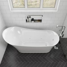 a white bath tub sitting in a bathroom next to a window and tiled flooring