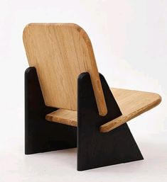 a wooden chair sitting on top of a white floor next to a black stand up