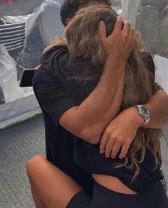 a man and woman hugging each other outside