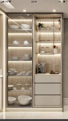 an open refrigerator with lots of white dishes on it's shelves in a kitchen