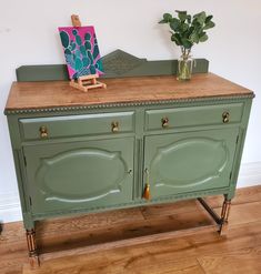 a sideboard with two drawers and a plant on top