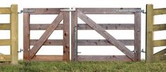 two wooden gates open on top of green grass