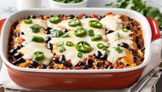 a red casserole dish filled with black beans, cheese and green peppers