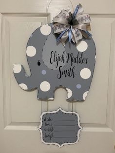 an elephant shaped door hanger with a bow on it's head and name