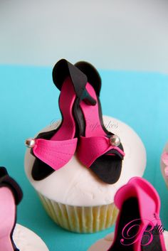 cupcakes with pink and black decorations on top of each one are decorated like ballet shoes