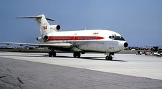 an airplane is sitting on the tarmac at an airport with other planes in the background