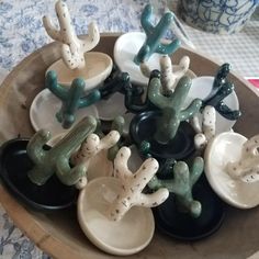 small ceramic cactus figurines sitting in a bowl