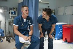 two men in scrubs are talking to each other