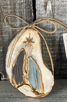 a nativity ornament hanging on a wooden wall next to a card holder