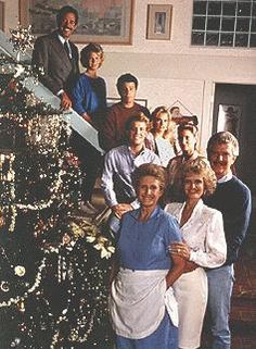 a group of people standing next to each other in front of a decorated christmas tree