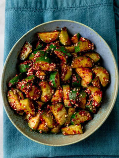 a white bowl filled with fried vegetables on top of a blue napkin