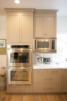 a modern kitchen with stainless steel appliances and wood flooring is pictured in this image