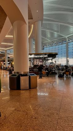 an airport terminal with luggage and people walking around