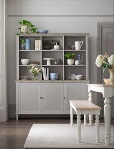 a dining room with white furniture and flowers on the table