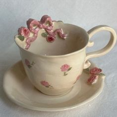 a cup and saucer with pink roses on it