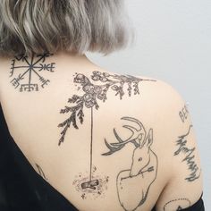 the back of a woman's shoulder with various tattoos on her upper and lower arm