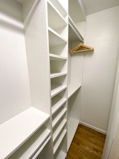 an empty walk in closet with white shelves