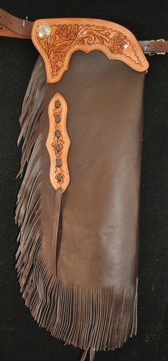 "Custom Chinks, Handmade in the U.S.A.! These chinks are made with a light weight, chocolate colored chap leather. They have 8 oz. tooling leather trim pieces, stained an antique Sheridan brown, with a full floral carved design on them. There is 6\" fringe on the leg and there are two chap snaps on each leg as well. These chinks are  a nice choice for light work or show. The measurements are as follows.  Waist: Adjustable from 28\" to 46\"  Thigh Measurement: Adjustable from 19\" to 26\"  Inseam: 22\"  Total Length from the top of the yoke to the bottom of the fringe: 31\"  Thanks for looking! Note: These chinks are made with odd lot chap leathers so exact colors may vary from pair to pair, though we can usually get very close. If this is a concern to you feel free to contact us to see wha Leather Chaps, Custom Chaps, Denim Chaps, Fur Chaps, Women’s Western Chaps, Western Chaps, Basement Decor, Chocolate Color, Cowboy Art