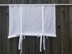 a white curtain hanging on the side of a wooden fence