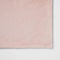 a pink area rug on top of a white wall