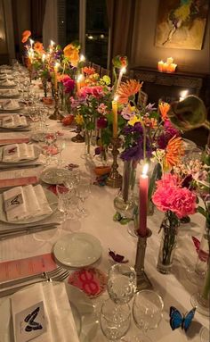 a long table is set with flowers and place settings for dinner guests to sit at