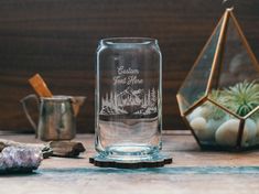 a clear glass vase sitting on top of a table next to rocks and air plants