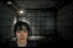 a person in a dark room with headphones on and an empty wall behind them