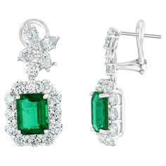 A beautiful and chic pair of drop earrings showcasing a cluster of brilliant mixed-cut diamonds, and emerald cut Emeralds set in an intricate and stylish design. 34 Mixed cut Diamonds weigh 4.27 carats total. 2 Emeralds weigh 4.45 carats in total. Made in 18k white gold. The color of these gemstones is ideal, with great luster/shine. Omega clasp with a post. Luxury Emerald Cut White Gold Diamond Earrings, Art Deco Drop Earrings, White Gold Drop Earrings, Emerald Earrings Drop, Diamond Chandelier Earrings, Diamond Chandelier, Arrow Earrings, Emerald Earrings Studs, Expensive Jewelry