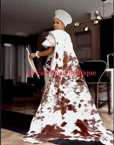 a woman in a brown and white dress is standing on the floor with a hat